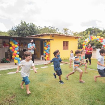 Kids running and playing in a colorful birthday party setting outdoors.